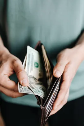 man taking money out of his wallet - Credit Rewards