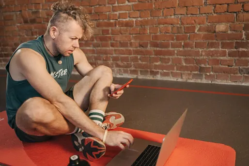 man with a phone and laptop -Monitor your credit
