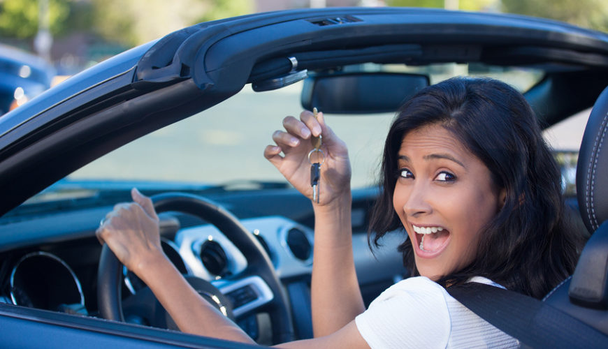 Closeup portrait young cheerful joyful smiling gorgeous woman holding up keys to her first new sports car. Customer satisfaction